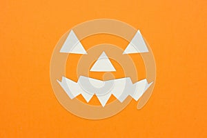 Halloween backdrop concept with layers of orange and white Â paper cut in the shape of a Jack O Lantern face, and paper artworks